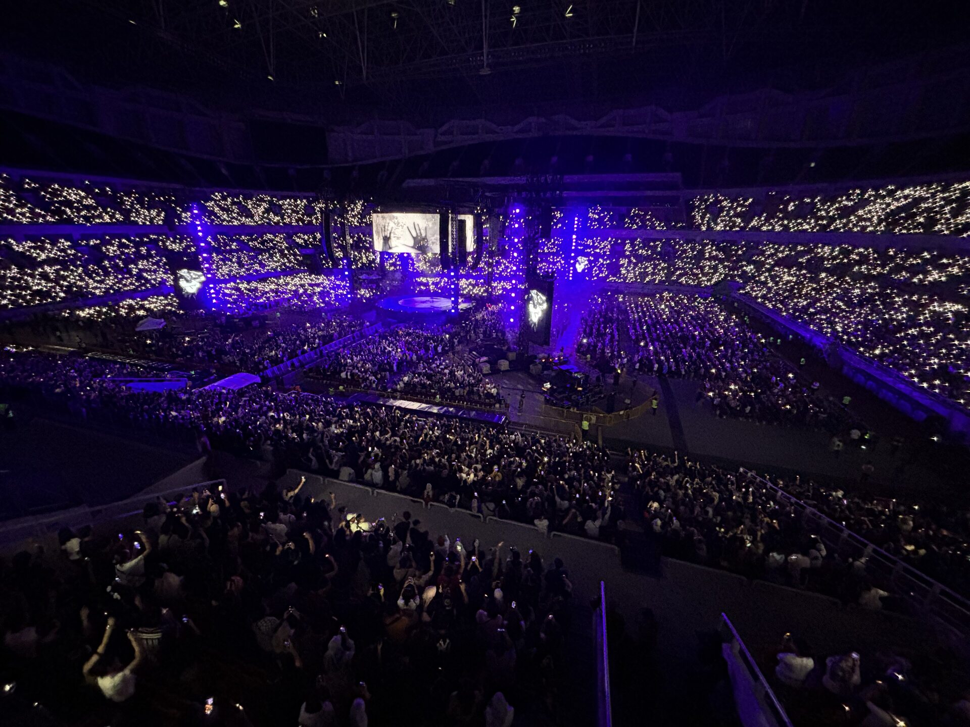 Suasana konser malam di Jakarta International Stadium dengan lampu panggung dan lautan penonton