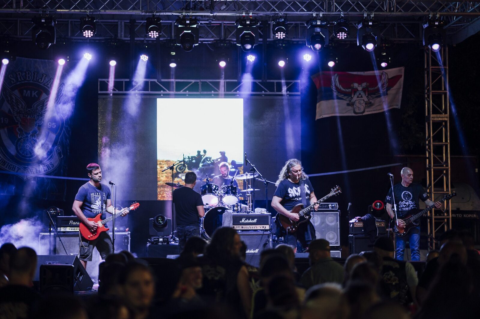 Penonton menikmati konser rock dengan lampu panggung berwarna-warni